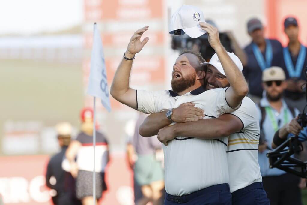 FARMINGDALE, NEW YORK - SEPTEMBER 28: (L-R) Shane Lowry of Team Europe celebrates with teammate Jon Rahm after Lowry halved the 18th hole and retain the Ryder Cup during the Sunday singles matches of the 2025 Ryder Cup at Black Course at Bethpage State Park Golf Course on September 28, 2025 in Farmingdale, New York. (Photo by Harry How/Getty Images)